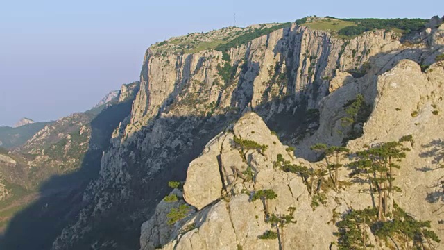 神奇的鸟瞰图。飞越克里米亚山脉的岩石峰。夏天的日落时间。超级慢动作视频下载