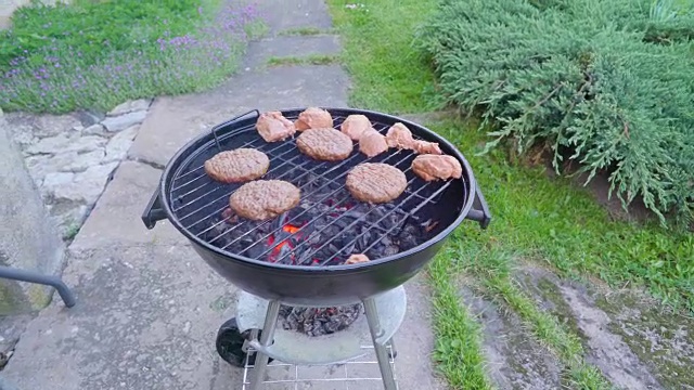 一个黑色的烤架，上面放着肉饼视频素材