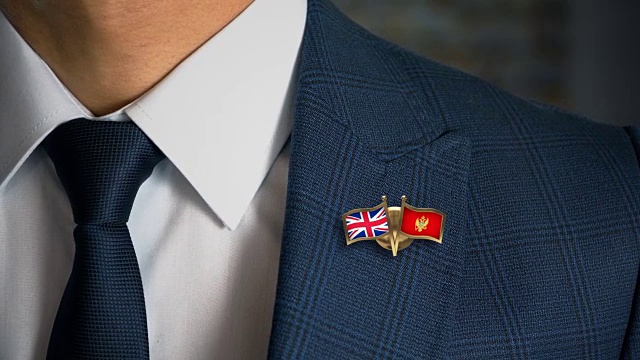 商人走向相机与朋友国家国旗别针英国-黑山视频素材