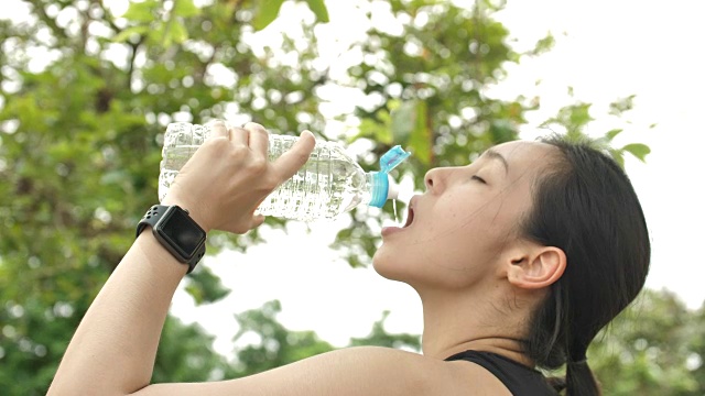 年轻女子运动后喝水视频素材