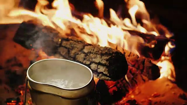 在徒步旅行中准备食物——水在金属水壶中煮沸视频素材