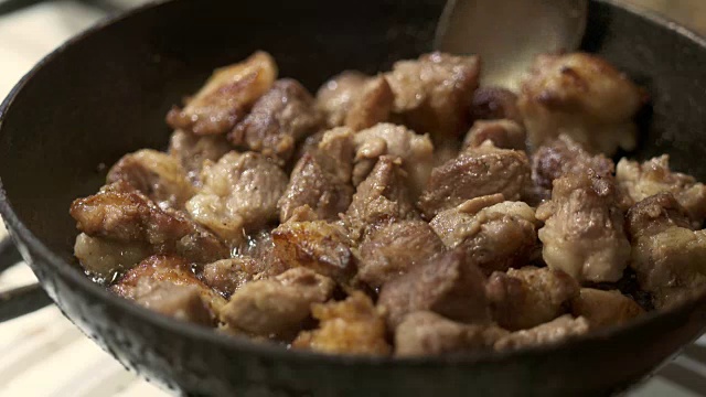 烹饪香酥炸猪肉。在加热的铁煎锅里炸肉片的特写视频素材