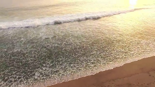 延伸轨道拍摄的海浪破在一个热带海滩日落视频下载