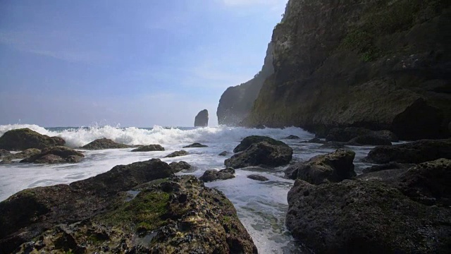 泡沫状的海浪拍打着印度尼西亚海岸线上的岩石视频素材