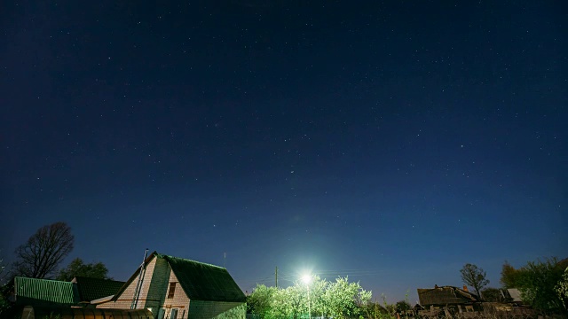 夜晚，村庄房屋上的星空背景。自然发光的星星夜景视频素材