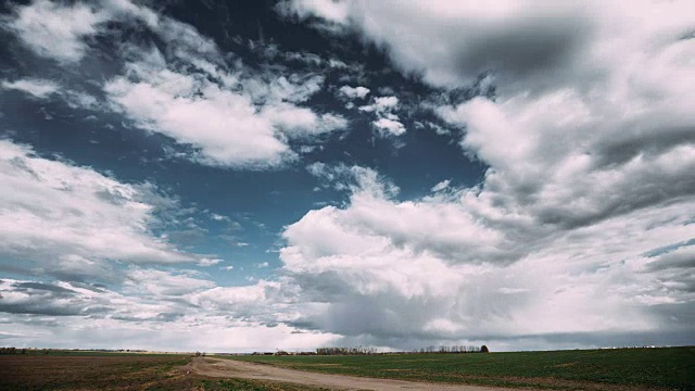 Time Lapse Time- Lapse Time- Lapse Of Rural Road Through Field Spring Meadow Landscape Under Scenic Dramatic Sky With Fluffy Clouds Before Rain.乡村乡村路穿过田野春天草地景观。农业和天气预报概念视频素材