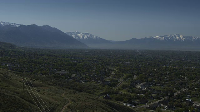 风景鸟瞰图的城市在山谷附近的雪山/雪松山，犹他州，美国视频素材