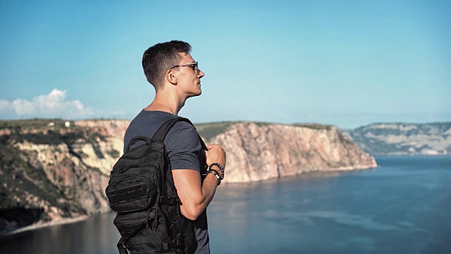 中等拍摄的背包客欧洲男人戴着太阳镜欣赏海港的迷人景色视频素材