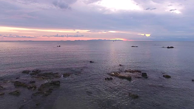 海洋和海滩与岩石在日落，鸟瞰图视频素材