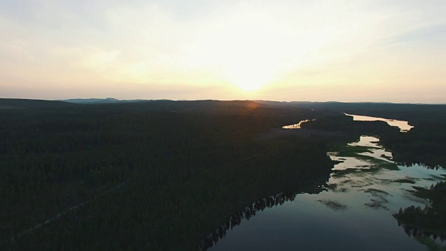 在日落时空中扫视风景。瑞典北部的湖泊和森林视频素材