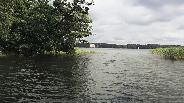 低飞在平静的河上。美丽的天空，平静的水面。树木倒映在水中。视频素材