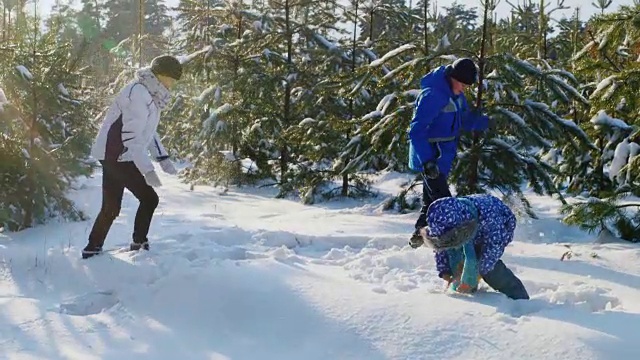 一个带着两个孩子的妇女和孩子们一起在雪地里称量体重视频素材