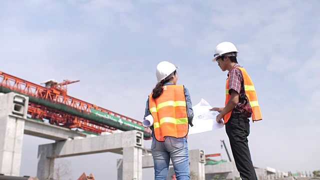 建筑师和工程师带着图纸在建筑工地交谈视频素材