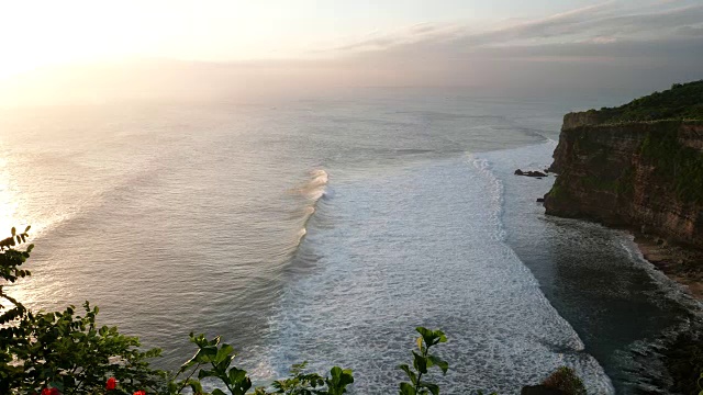 日落时分的乌鲁瓦图神庙，阳光照在巴厘岛的破浪上视频素材