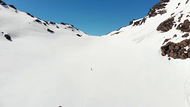 空中飞行:飞过正在走向雪山山顶的徒步旅行者视频素材