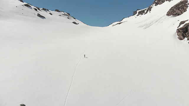 空中飞行:飞过正在走向雪山山顶的徒步旅行者视频素材