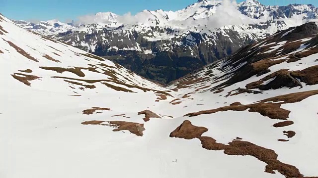 空中飞行:飞过正在走向雪山山顶的徒步旅行者视频素材