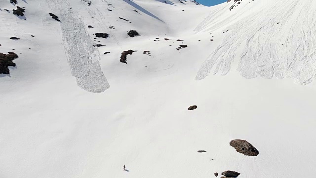 空中飞行:飞过正在走向雪山山顶的徒步旅行者视频素材