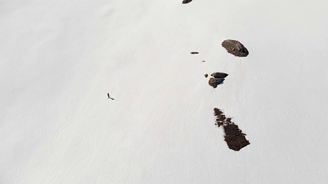 空中飞行:飞过正在走向雪山山顶的徒步旅行者视频素材