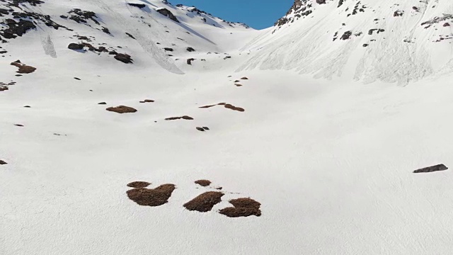 空中飞行:飞过正在走向雪山山顶的徒步旅行者视频素材