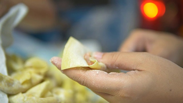 亚洲妇女手工制作馄饨和饺子馅。视频素材