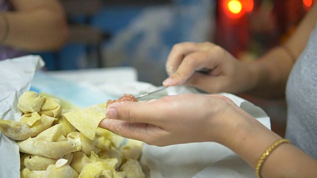 亚洲妇女手工制作馄饨和饺子馅。视频素材