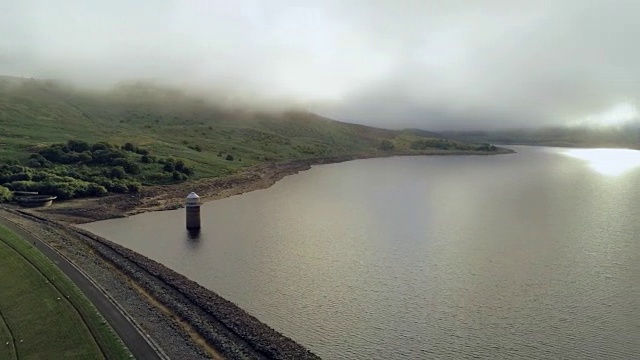 鸟瞰图，快速平移。无人机全景Llyn Celyn水库大坝和羊群在草地上在威尔士视频素材