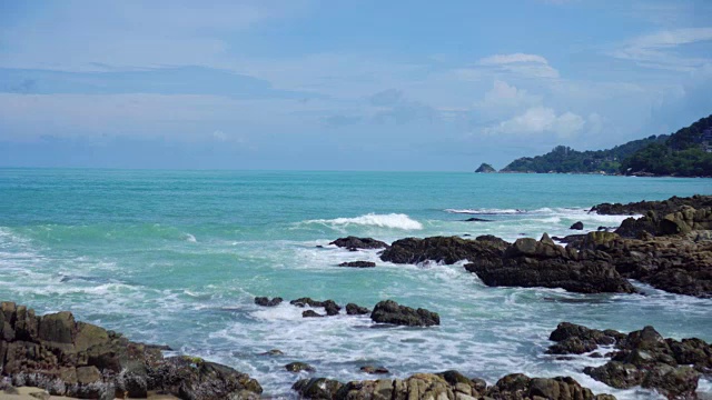 热带海滩，海浪，沙子和岩石与夏天的蓝天视频素材