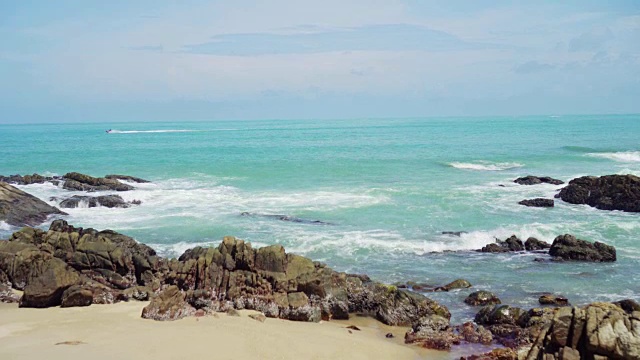 热带海滩，海浪，沙子和岩石与夏天的蓝天视频素材