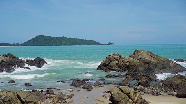 热带海滩，海浪，沙子和岩石与夏天的蓝天视频素材