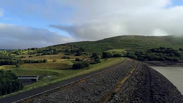 鸟瞰图，向前侧移。无人机全景Llyn Celyn水库大坝和绿地在威尔士视频素材