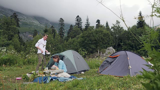 朋友们在夏季露营时休息，而游客徒步登山视频素材