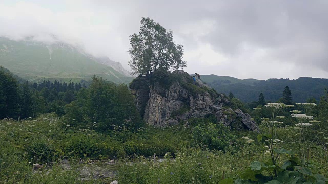 游客攀登岩壁上的青山景观，同时徒步旅行视频素材