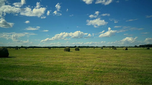 一捆捆干草在田野上与美丽的云天空视频素材