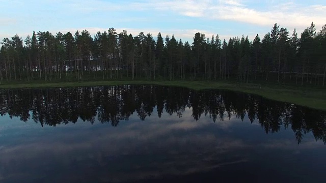 空中淘洗松林中平静的湖面。瑞典北部美丽的风景视频素材