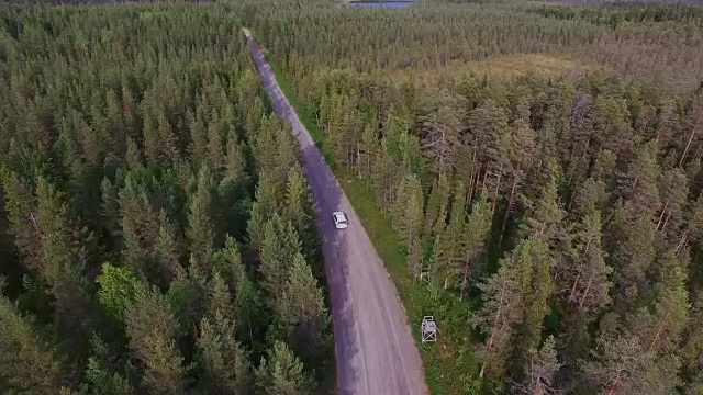 空中:在森林的砾石路上行驶的汽车视频素材