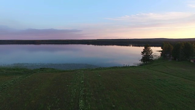 航拍日落时瑞典北部田园诗般的风景。夏天的湖和树视频素材