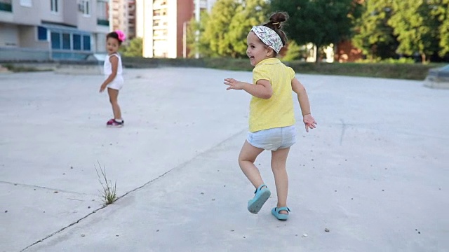 漂亮的幼童在公园里追逐嬉戏视频素材