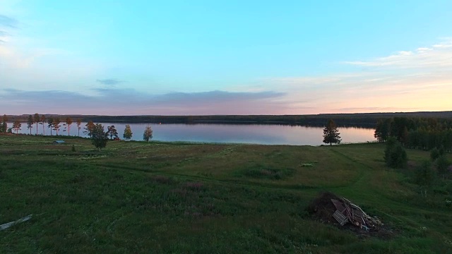 在瑞典北部日落时飞过湖面。航拍夏季景观视频素材