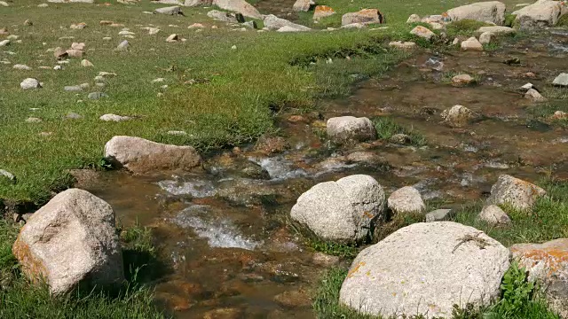 清澈的溪水在山间流淌。透明的水在山河视频素材