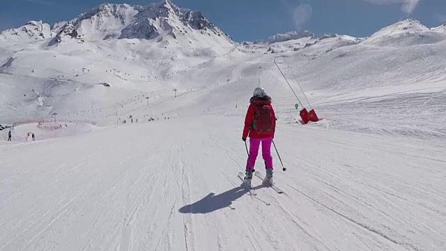 在运动中，滑雪者从山上度假村的滑雪坡上滑雪视频素材