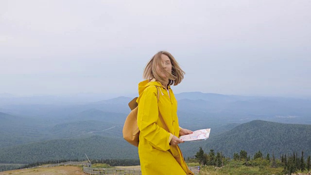 年轻女性徒步旅行者从山顶看地图视频素材