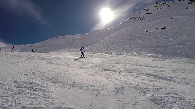 滑雪者快速滑下山坡，在转弯时喷洒雪粉视频素材