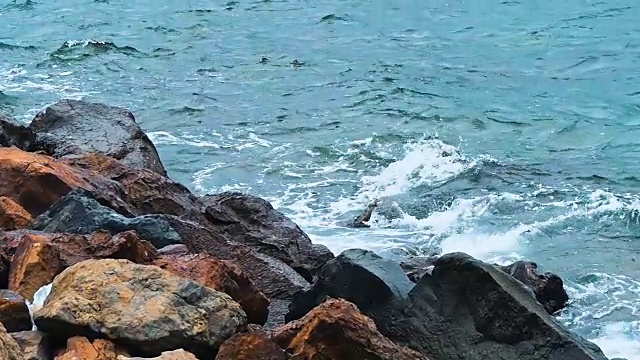 强烈的海浪拍打着布满岩石的海滩视频素材