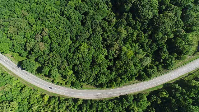 鸟瞰图，汽车沿着公路行驶。路是微笑的形式。视频素材