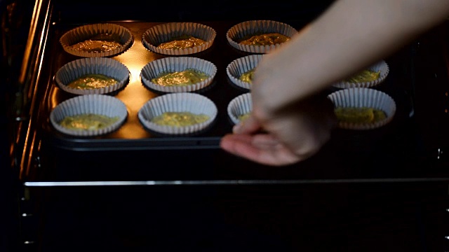 女人把面糊蛋糕在烤箱在厨房特写。烹饪时间。视频素材