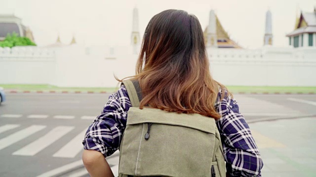 慢动作-旅行者背包亚洲女人旅行在曼谷，泰国。快乐的年轻女性在惊人的地标假日旅行，享受她的旅程在传统城市。视频素材