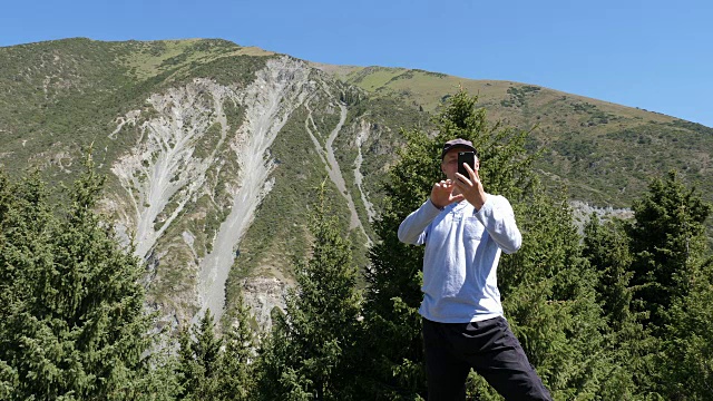 旅游者在登山时使用手机进行视频通话视频素材