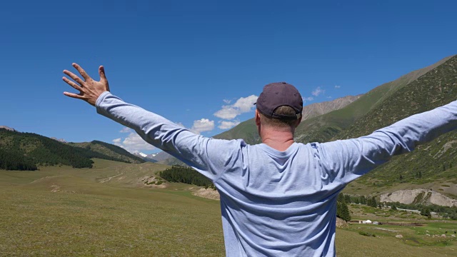 人站在山上，在青山和高原景观上伸出双臂视频素材