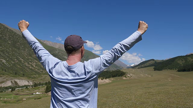 快乐的人站着，伸开双手，在山景中享受生活视频素材